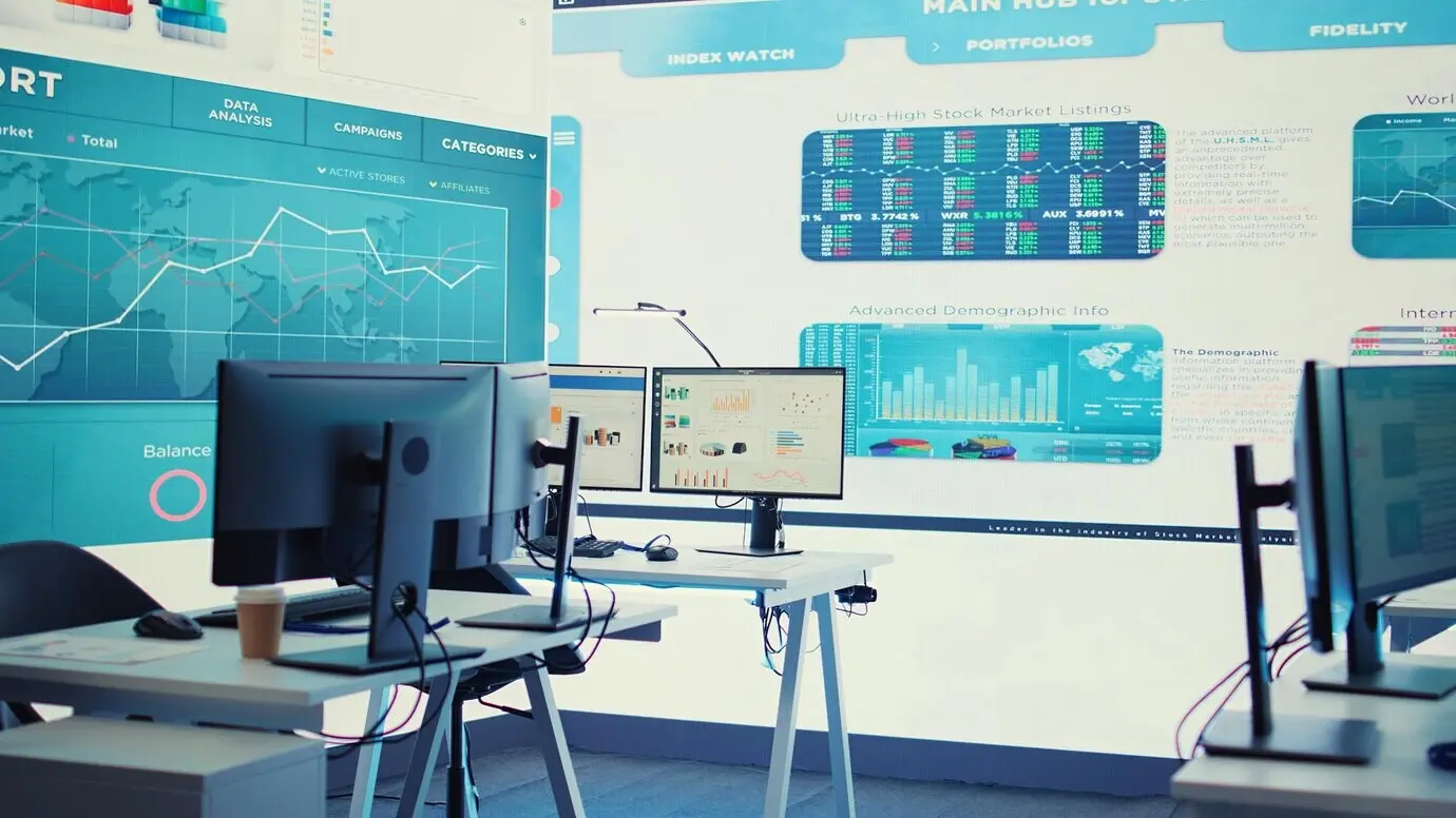 Leerer Konferenzraum mit mehreren Arbeitsplätzen, die mit Computern ausgestattet sind.